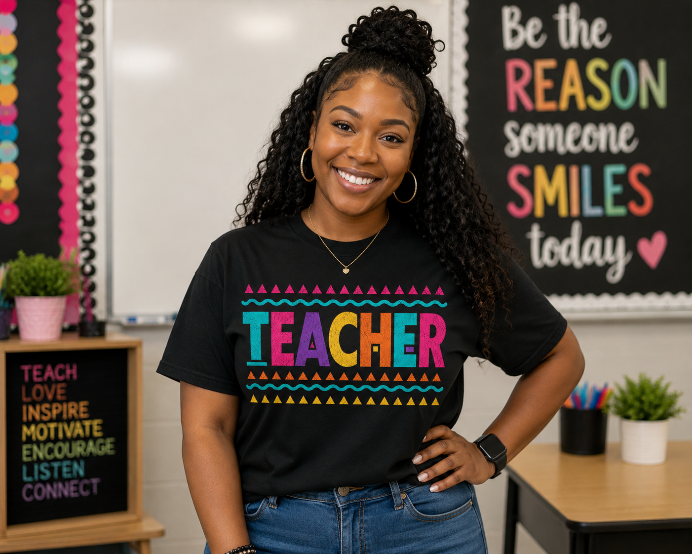 Black teacher wearing a black t shirt that says TEACHER in brigh colors including, teal, pink, purple, yellow and orange.
